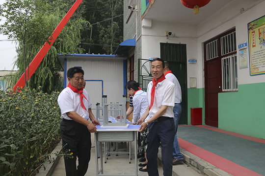 乐投官网平台领导与学生一起将桌椅搬进教室