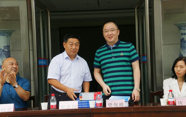 新乡市牧野区税务局党委书记、局长樊保峰向乐投官网平台党委书记张会民赠送税法知识书籍.jpg